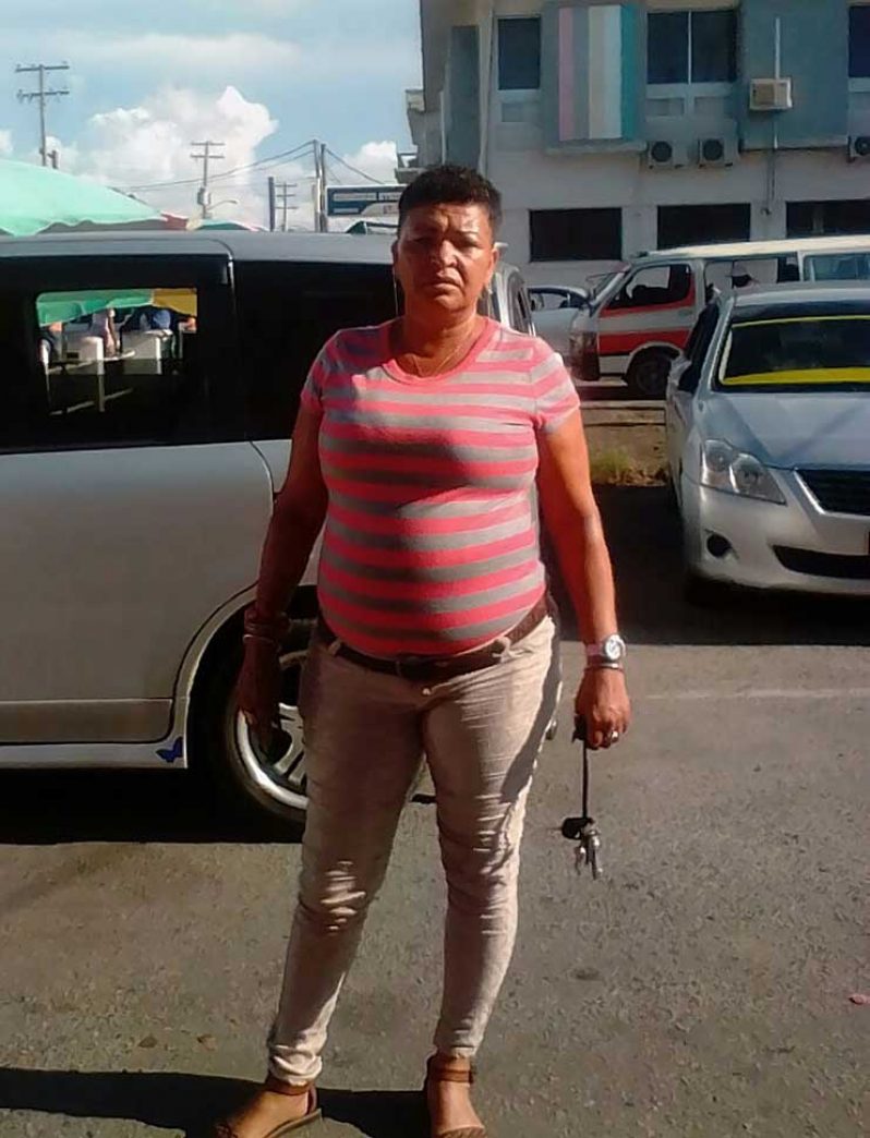 Female taxi driver Loraine Fernandes, posing next to her car.