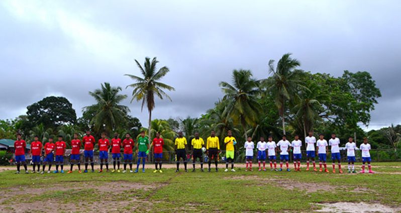 Two football teams which contested the finals of the Digicel Football championships finals at Santa Rosa in Moruca stand alongside game officials prior to the start of the match