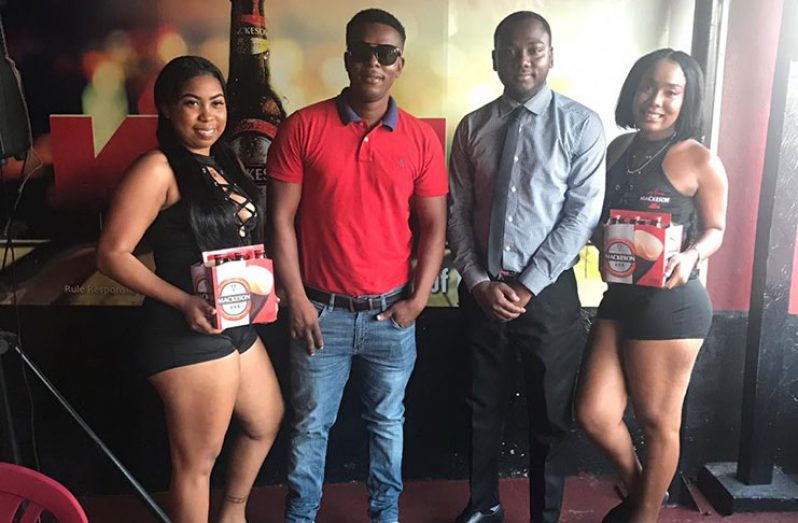 DJ Akelo (second from left) and Mackeson Brand Representative Keon Persaud, along with the ‘Mackeson ladies’ at the launch of the ‘King of Di Crowd’ DJ Competition.