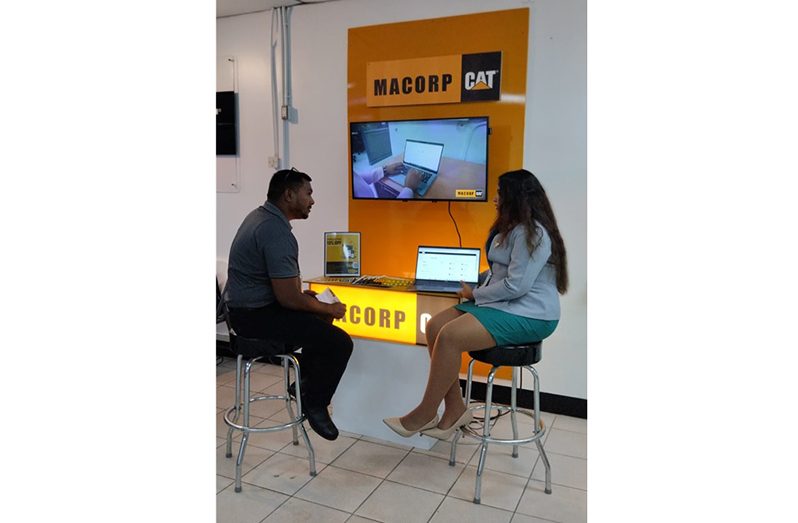 A Sales Representative assisting a customer at the PCC booth