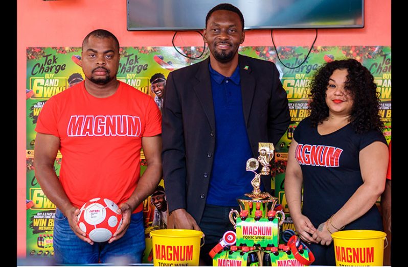 Magnum brand representative Edison Jefford (first from left), Director of Sport Christopher Jones and a Magnum model at the launch of the Magnum ‘Tek Charge and Win’ Futsal Tournament. (Delano Williams photo)