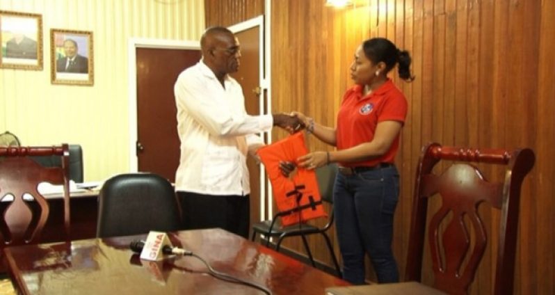 Public Relations Officer of MARAD, Akousa Mc Pherson, presenting a life jacket to Region 10 Chairman Renis Morian