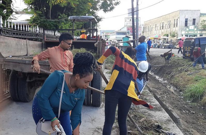 Mayor of Georgetown Pandit Ubraj Narine; M&CC councillors and other workers assist with the clean-up on Sunday