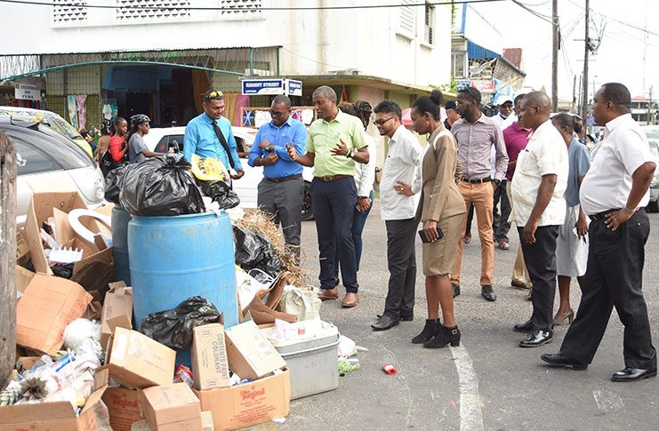 Georgetown Mayor, Ubraj Narine and Town Clerk (ag) Sharon Harry (fourth and fifth from left) examine the brazen act of improper garbage disposal on the roadside of the Regent and Alexander Street intersection.  (Samuel Maughn photo)