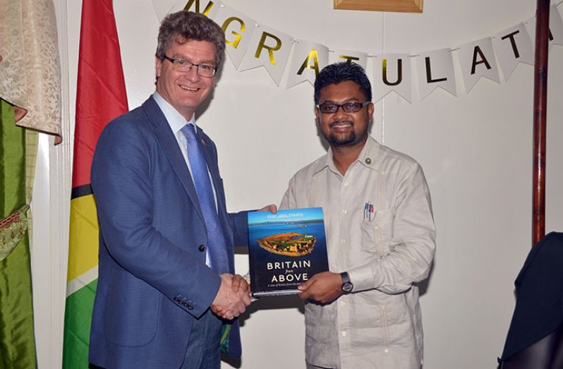 British High Commission to Guyana, Greg Quinn, (left) handing over a copy of the book ‘Britain from Above: A view of Britain from the past to present” to Georgetown Mayor Ubraj Narine (Adrian Narine photo)