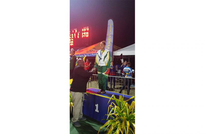 Aleka Persaud on the podium last night after winning gold in the 100M butterfly.