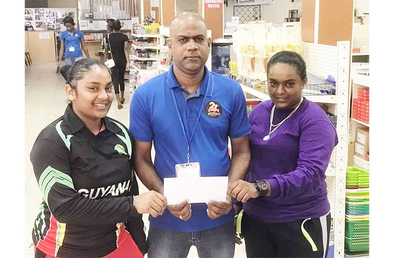Danny Ramnarine hands over sponsorship to RHTYSC female cricketer Trisha Hardat and Stephanie Ramdas