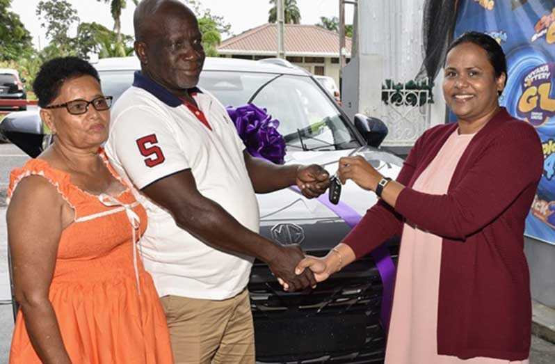 Mr.  Jerrick Southwell and his wife collect the keys for his brand-new MG SUV from Ms. Kalima Ali, General Manager, Guyana Lottery Company Limited