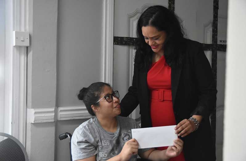 Minister of Human Services and Social Security, Vindhya Persaud, hands over a cheque to beneficiary Raquel Lam who plans to open a small grocery business in Mora Creek, Bartica (Sachin Persaud Photos)