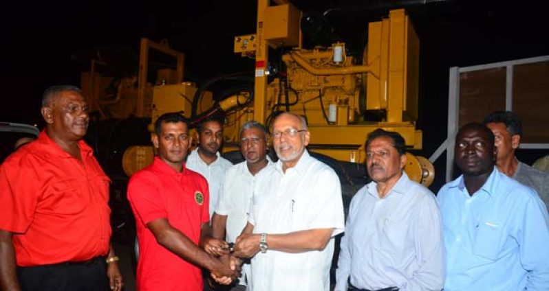 President Donald Ramotar, at centre, hands over the keys for the new pumps, one of which is seen in the background (Adrian Narine photo)