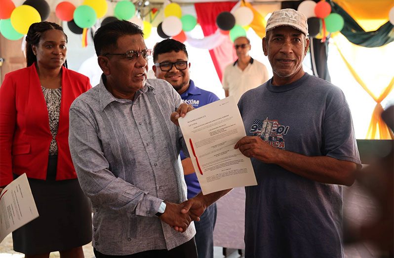 Minister Mustapha hands over a lease to one of the farmers during the MMA Open Day