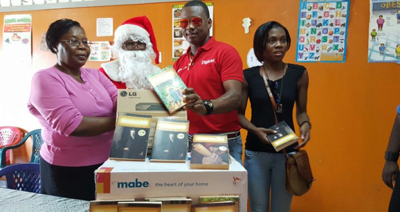 Christopher Barnwell in process of presenting the gifts to Sophia Care Centre Administrator Roxanne Blenman