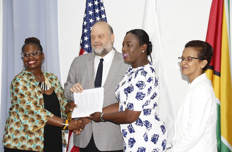 Education Minister Nicolette Henry accepts the signed Memorandum of Understanding (MoU) from US ambassador to Guyana Perry Holloway. They stand along with Peace Corps Guyana Country Director Kury Cobham (left) and Deputy Chief Education Officer of (Admin), Ingrid Trotman (Samuel Maughn photo)