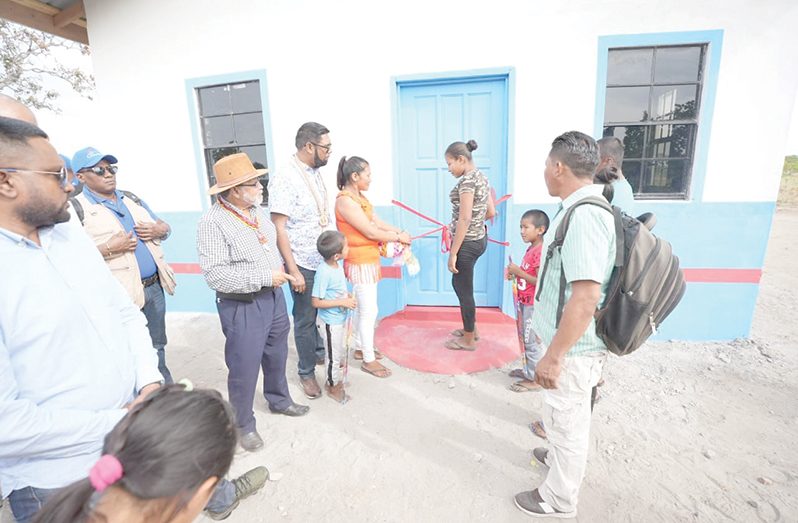 President, Dr Irfaan Ali, presents the new house to Richard Gouveia, Carin Bernard and their five children (Office of the President photo)