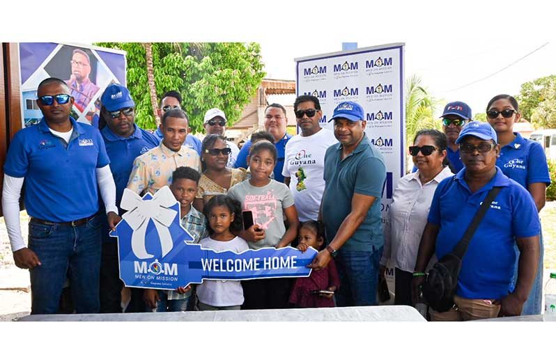 Minister within the Ministry of Public Works, Deodat Indar; Regional Chairwoman, Vilma DeSilva; MOM Executives; Shervin De Younge and family poses with key to new home