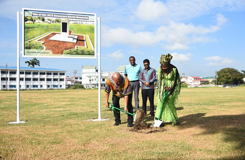 Minister of Social Cohesion, Dr. George Norton (left) and President of the Ghana Day Organisation, Sister Penda Guyan turn the sod at Parade Ground on Sunday where the new memorial will be placed. In the background are Deputy Mayor Alfred Mentore (left) and Mayor of Georgetown, Ubraj Narine (Samuel Maughn photo)