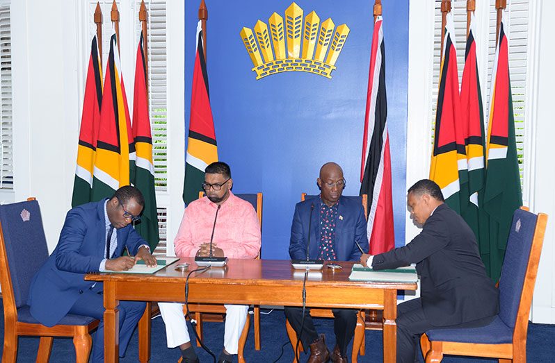 Minister of Foreign Affairs and International Cooperation Hugh Todd and Trinidad and Tobago’s Minister of Foreign and CARICOM Affairs, Dr Amery Browne sign the Memorandum of Understanding (MoU) in the presence of Guyana’s President, Dr Irfaan Ali and Prime Minister of Trinidad and Tobago, Dr Keith Rowley (Delano Williams photo)