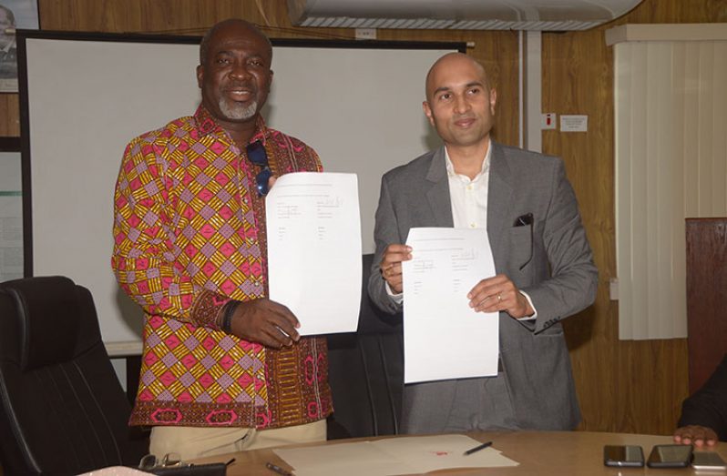 Georgetown Chamber of Commerce and Industry (GCCI) President, Nicholas Boyer and Executive Secretary (ag) of the Guyana-Ghana Chamber, Nuertey Adzeman, display the two-year Memorandum of Understanding (MoU) signed on Wednesday (Adrian Narine photo)