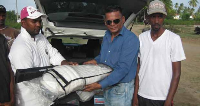 MP Faizal Jaffarally presents the gear to TCC President Majeed Khan Mohamed at the Topoo Ground.