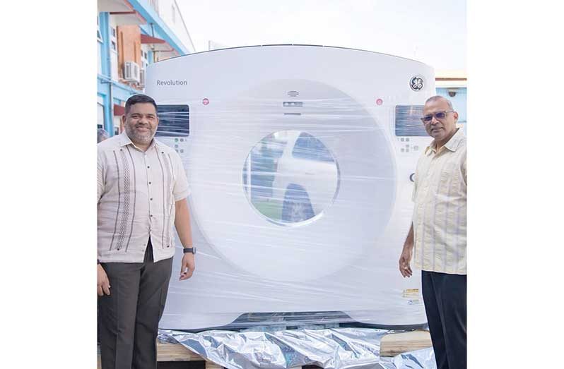 Minister of Health, Dr Frank Anthony and CEO of the Georgetown Public Hospital Corporation, Robbie Rambarran, alongside the new MRI machine currently being installed