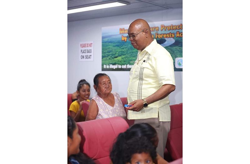 Minister of Public Works, Bishop Juan Edghill, interacting with passengers on the MV MA Lisha on the route to Region One