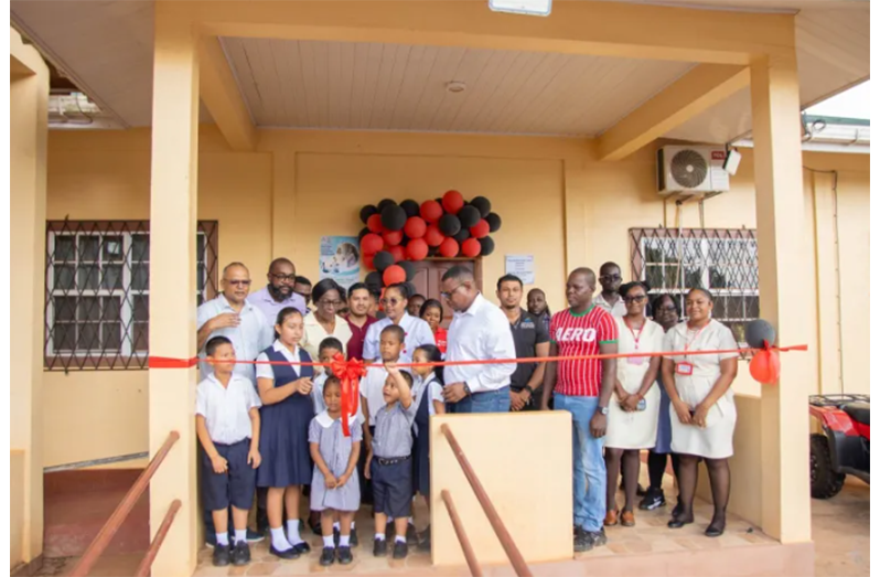 Minister of Health Dr. Frank Anthony, along with residents and staff participating in the ribbon cutting