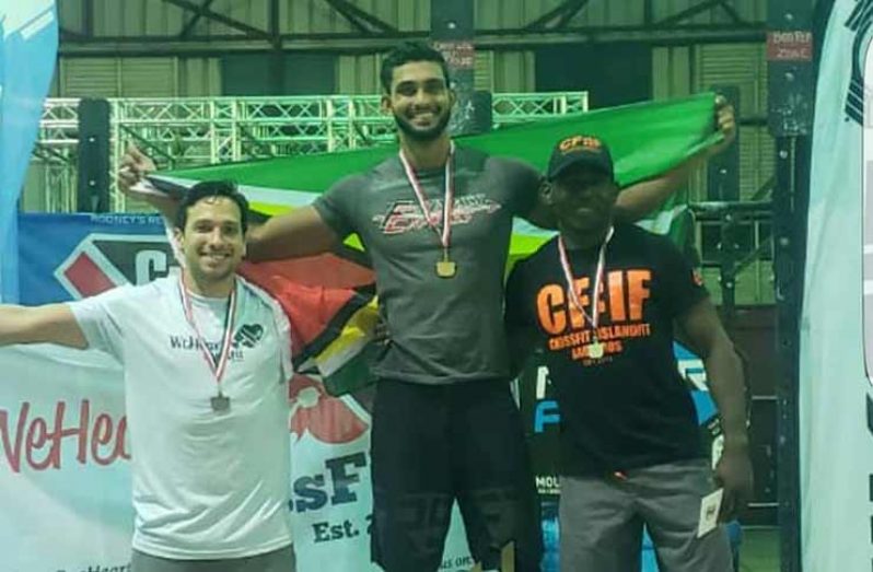 Dillon Mahadeo stands on podium after copping gold at the T&T CrossFit Challenge over the weekend.