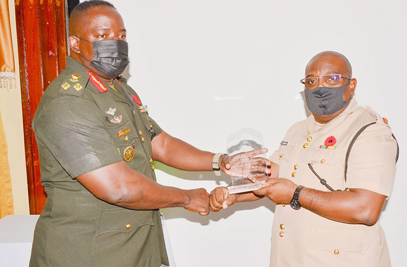 Chief of Staff, Brigadier Godfrey Bess presents Major Marlon Daniels with the Best Graduating student plaque