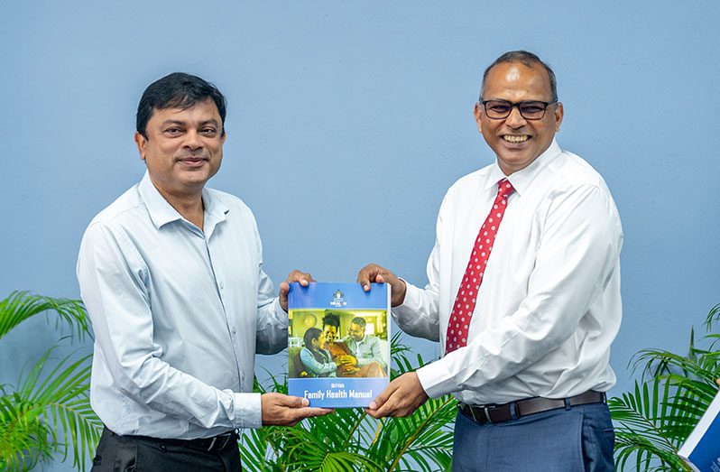 Minister of Health, Dr Frank Anthony, hands the manual over to Chief Medical Officer, Dr Narine Singh (left) on Tuesday (Delano Williams Photo)