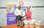 COO of Marcia's Products, Ms Marcia Gonsalves-Kwang receives the Made in Guyana Certificate from GNBS Executive Director (Ag.), Mr. Al Fraser