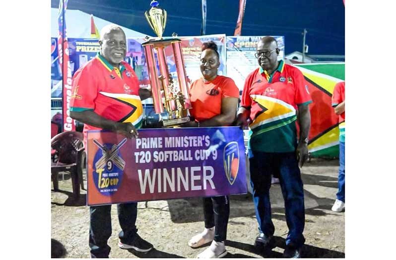 Prime Minister Mark Phillips, left, hands over the winning trophy to 4R Lioness skipper Tamica Wilson in the presence of GSCL President, Ian John.