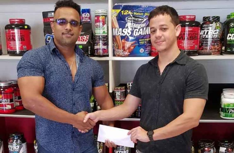 GBBFF Vice-President Seon Satrohan receives the sponsorship package from Fitness Express’s Jamie McDonald