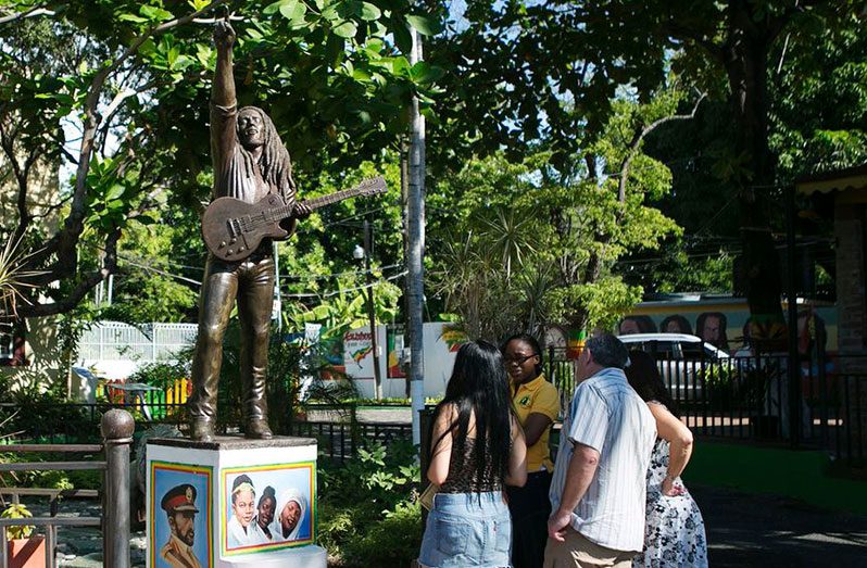 Tourists view a statue of Bob Marley outside the Bob Marley Museum in Kingston, December 13, 2013. (REUTERS/Gilbert Bellamy)