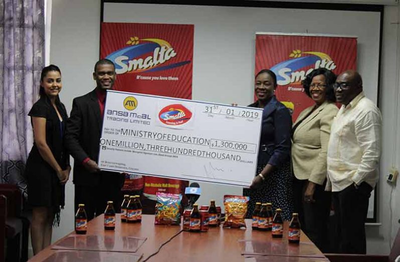 Minister Henry receiving the cheque from Business Unit Head of Ansa McAL Non-Alcoholic Division, Errol Nelson