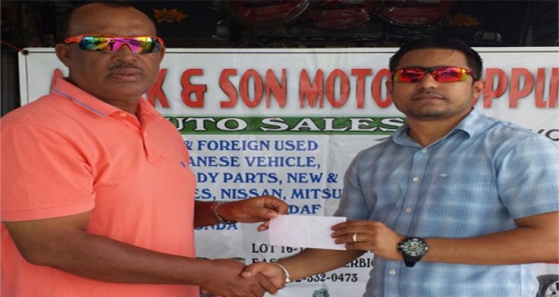 Former national player, coach and selector Hubern Evans, left, collects the sponsorship cheque from Ray Ali, Managing Director of Ashiek and Son Motor Supplies and Auto Sales