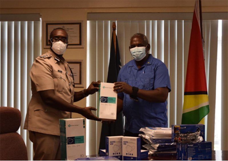 Minister of Home Affairs, Robeson Benn, handing over PPE to the Commissioner of Police (ag) Nigel Hoppie