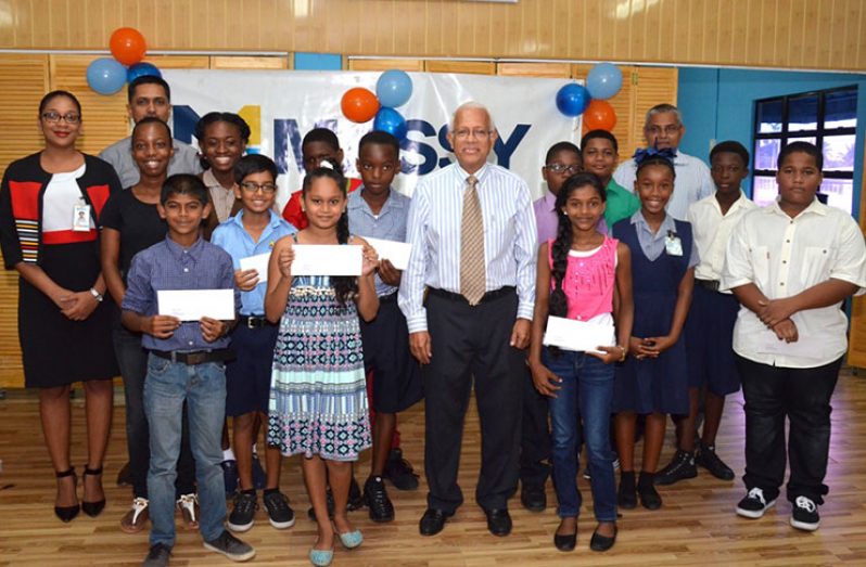 The bursary awardees with Mr. Deo Persaud (centre) and senior executives of the company.