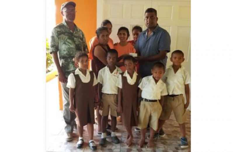 Here, vice-president Mathura hands over the cash to Abrahim in the presence of some children of the home. Secretary Frederick Halley is at extreme left.