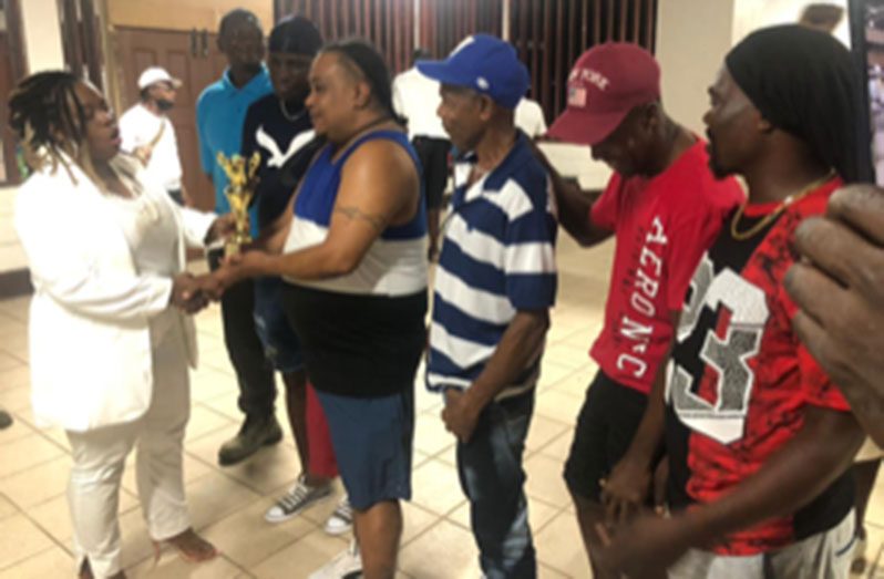 Mayor of Linden, Mrs Waneka Arrindell, left, presents MVP trophy to Swag Boss, Arthur Chung, in the presence of other members of the team