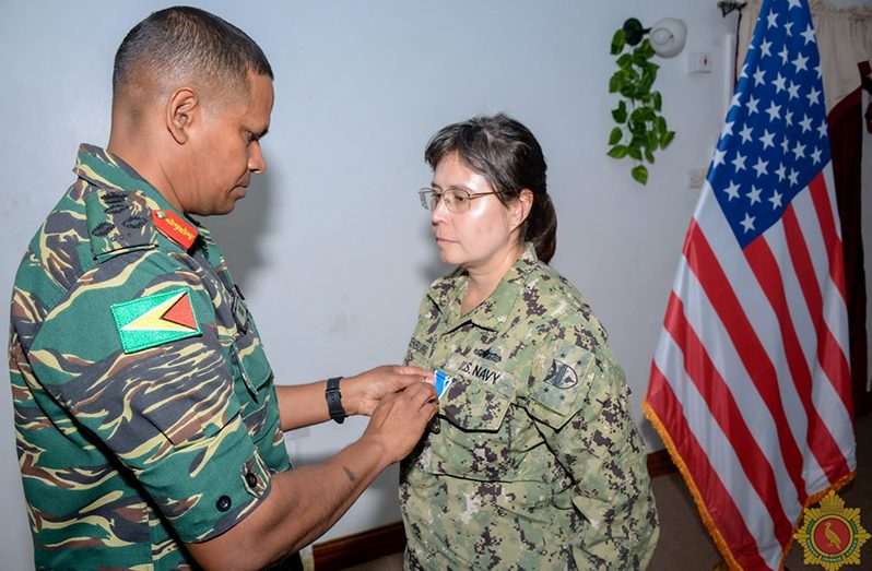 Chief-of-Staff, Brigadier Omar Khan, pins outgoing US Embassy Commander of the Security Cooperation Office, Lieutenant Commander