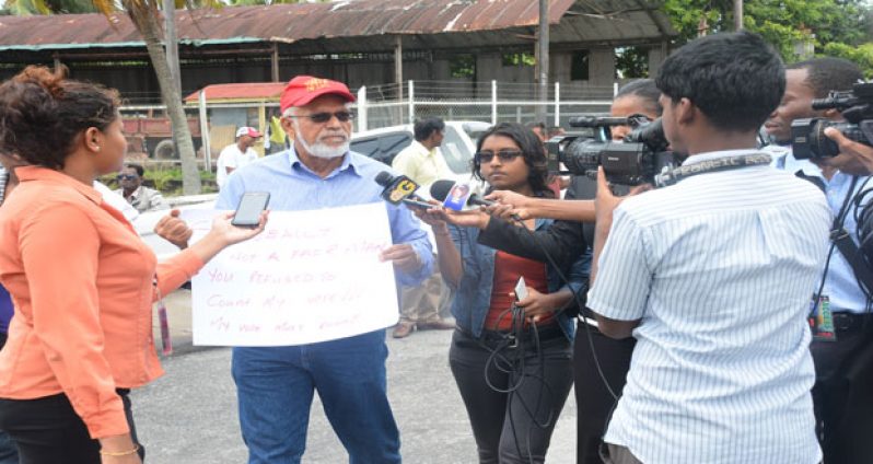 PPP/C leader, Mr. Donald Ramotar speaking to members of the media yesterday outside GECOM’s office, where he and supporters protested the 2015 election results