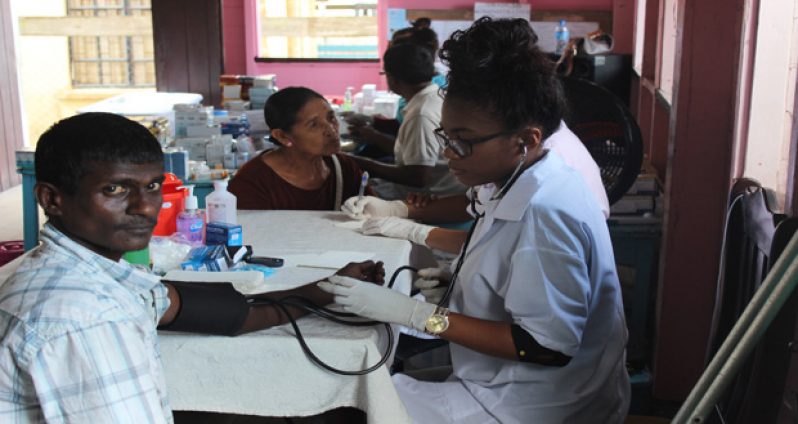One of the medical personnel administering medical services to a resident of Berbice