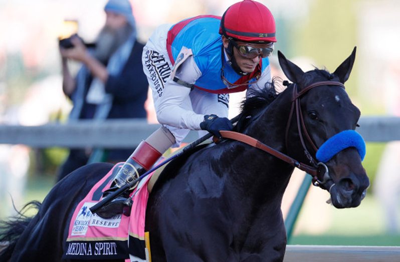 Medina Spirit, ridden by jockey John Velazquez, crosses the finish line to win the 147th running of the Kentucky Derby.
