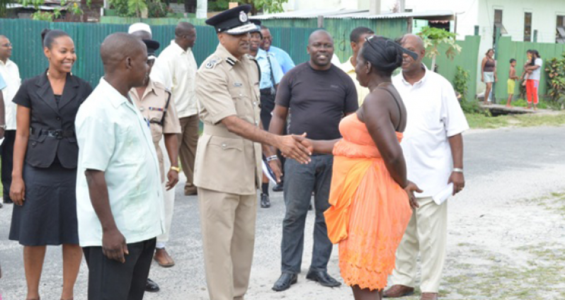 Acting Police Commissioner Seelall Persaud is seen greeting a member of the Albouystown community at launching of the Albouystown Impact Project, which was held at Independence Boulevard, Hunter Street, Albouystown