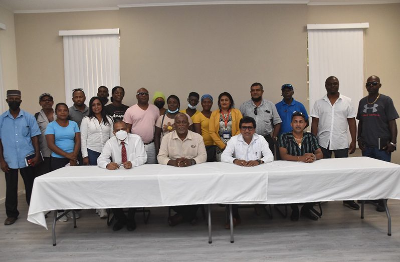 Prime Minister, Brigadier (Ret'd) Mark Phillips (seated second left); Attorney-General Anil Nandlall, S.C. (seated second right); Health Minister Dr. Frank Anthony (seated first left) and other officials share a moment with residents of Golden Grove (DPI photo)