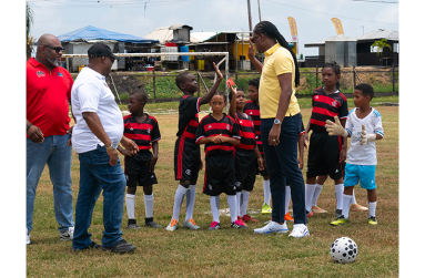Courts optical brand manager Richard Simpson, Minister Steven Jacobs, and Petra director Troy Mendonca meeting players