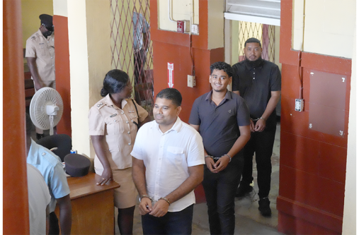 Opposition Leader Azruddin Mohamed, his driver Eugene Thorne and videographer Mario Mohamed at the Georgetown Magistrates’ Courts on Friday, where they were each granted bail on firearm, ammunition and obstruction of justice charges