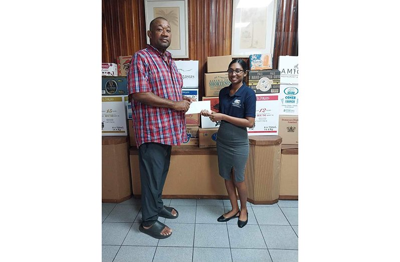 Fareeza Kasim of CCI makes a donation to Secretary Hilbert Foster