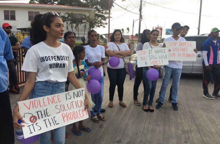 Marchers bearing placards with messages against domestic violence