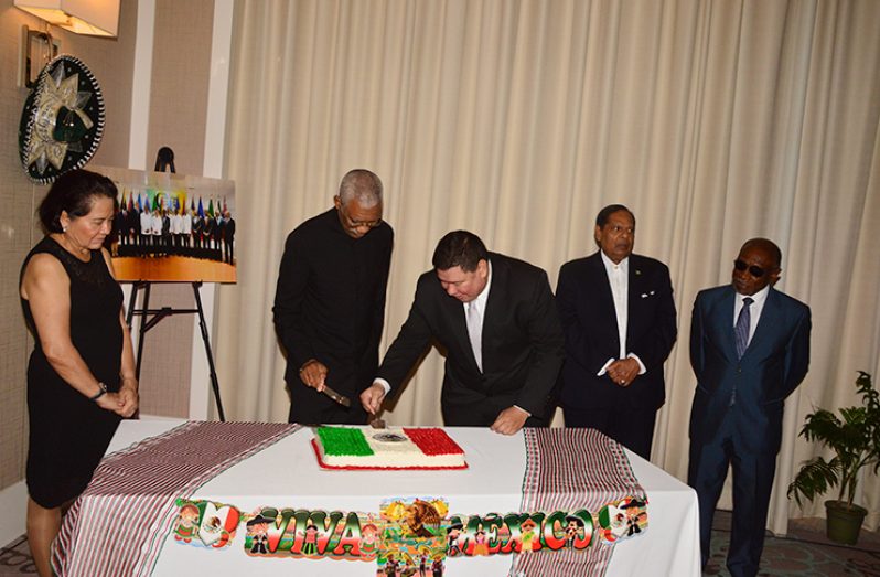 President David Granger and Mexican Ambassador Ivan Roberto Sierra-Medel cut the ceremonial cake marking Mexico’s 208th Independence Anniversary Friday evening,  as Prime Minister Moses Nagamootoo; First Lady, Sandra Granger; and Second Vice-President and Minister of Foreign Affairs, Carl Greenidge savour the moment (Photo by Adrian Narine)